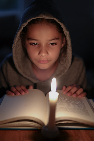 Before girl reading with candlelight