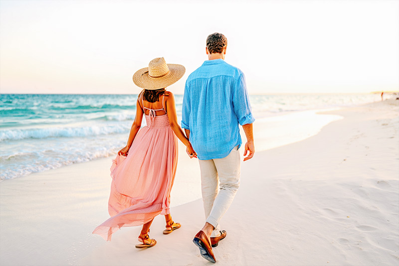 After couple walking hand in hand on the white sands of Playa del Carmen