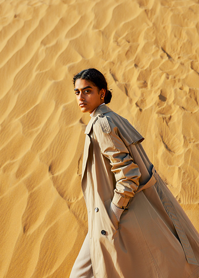 After fashion model walks across golden sand dunes