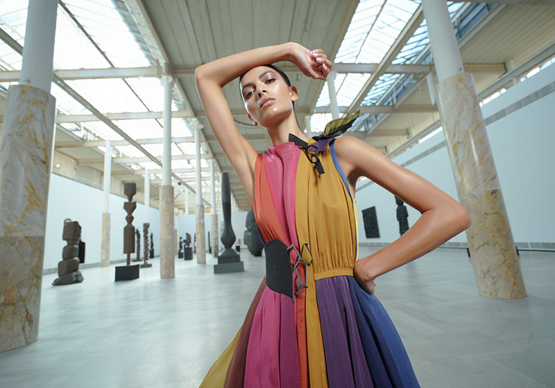 Before model wearing a colorful avant-garde dress