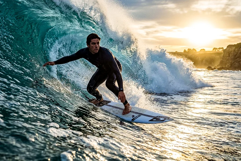With preset applied - A surfer catching a wave at sunrise in Hawaii
