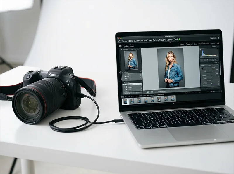 Camera connected to a laptop via USB with Lightroom Classic tethered capture active 