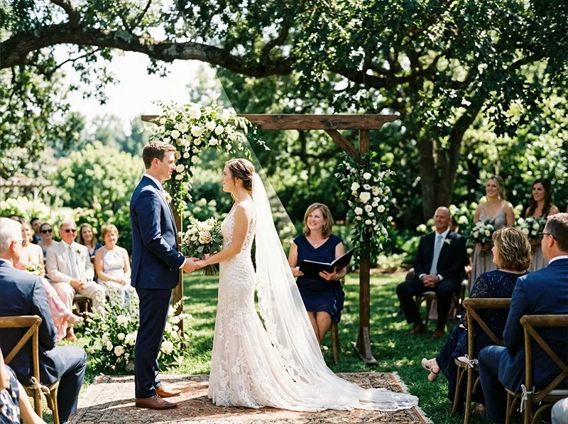Bride and groom exchanging vows outdoors, half in direct sun and half in dappled tree shade during an outdoor wedding ceremony